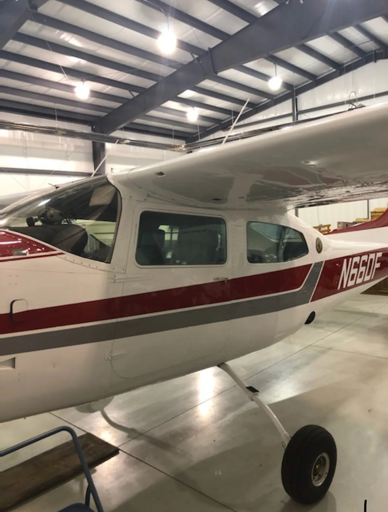 Close-up side view of the cockpit and cabin of a white and red aircraft N66DF.