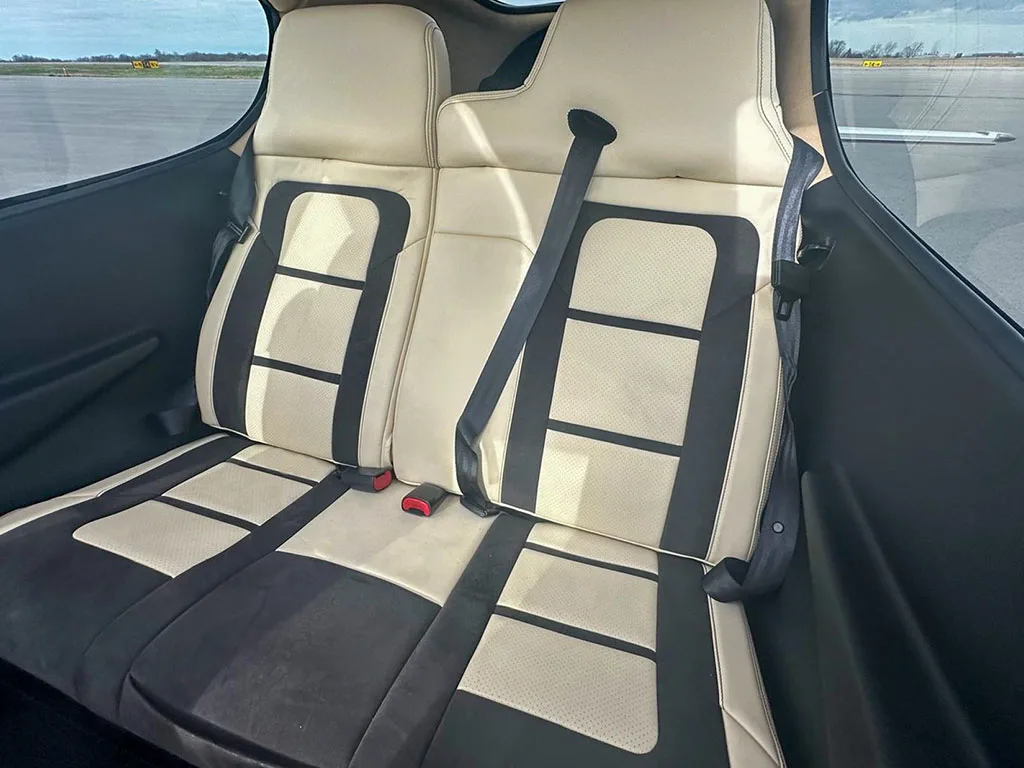 The rear cabin seats of a Cirrus SR22 aircraft, upholstered in two-tone beige and black.