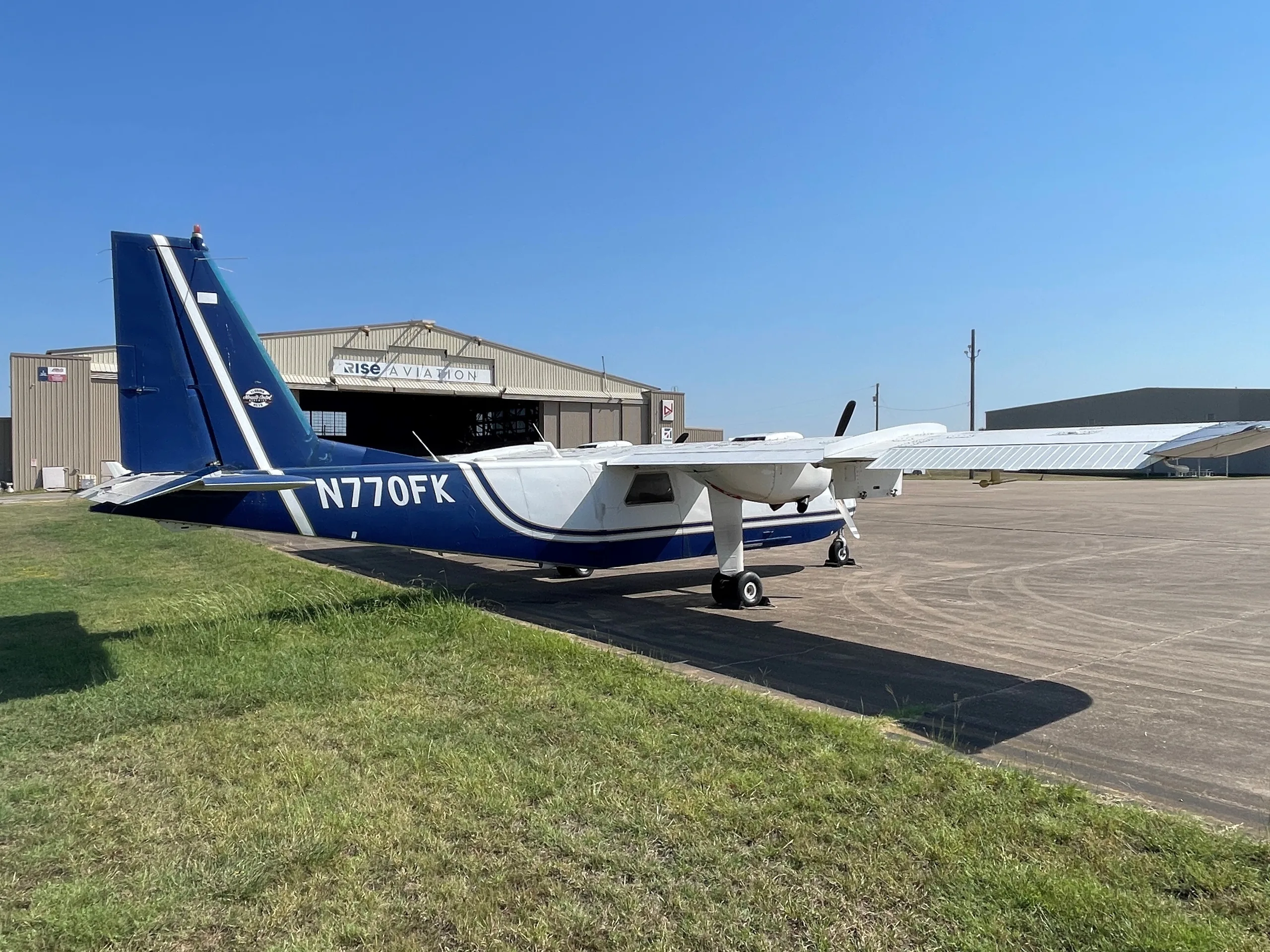 Aircraft N770FK parked in front of a hangar.