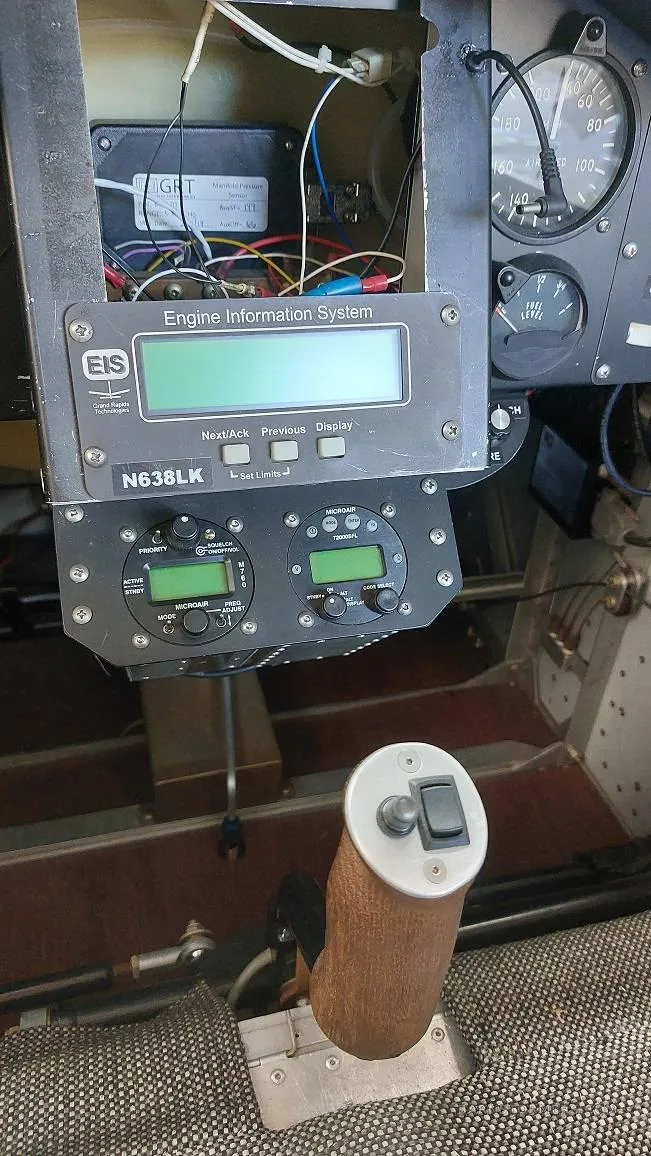 A view of the aircraft's cockpit showing the engine information system, other gauges, and the control stick.