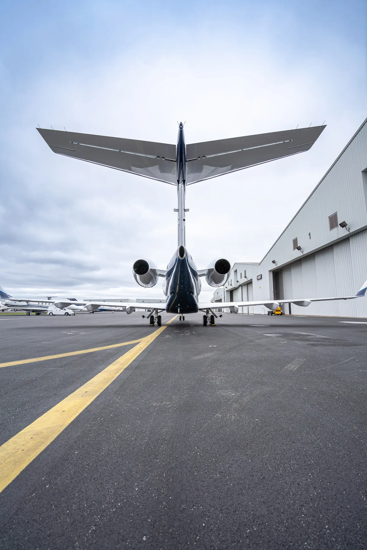 A luxurious private jet interior with tan leather seats and dark blankets.