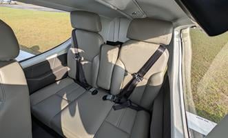 The interior of the aircraft shows the front seats with seatbelts.
