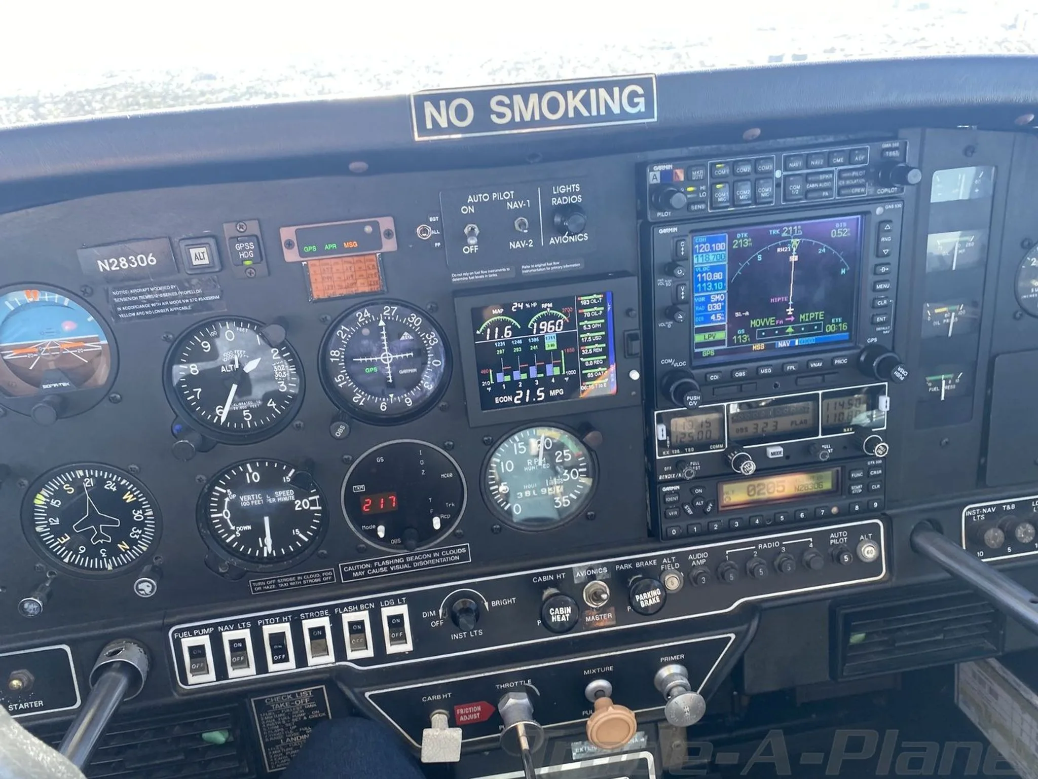 A close-up of the Grumman AA5B Tiger's instrument panel, N28306, featuring analog gauges and modern displays.
