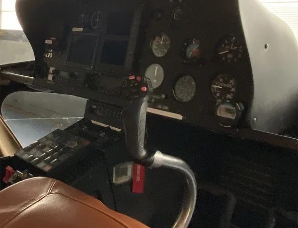 Helicopter cockpit with control stick and instrument panel.