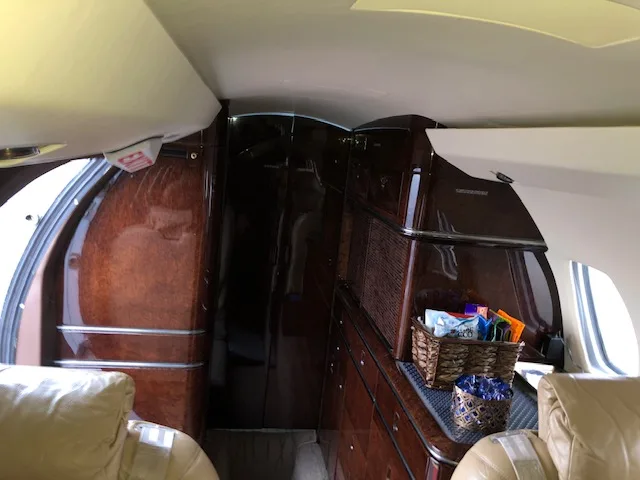Interior view of the aircraft with wooden cabinets and a small window.