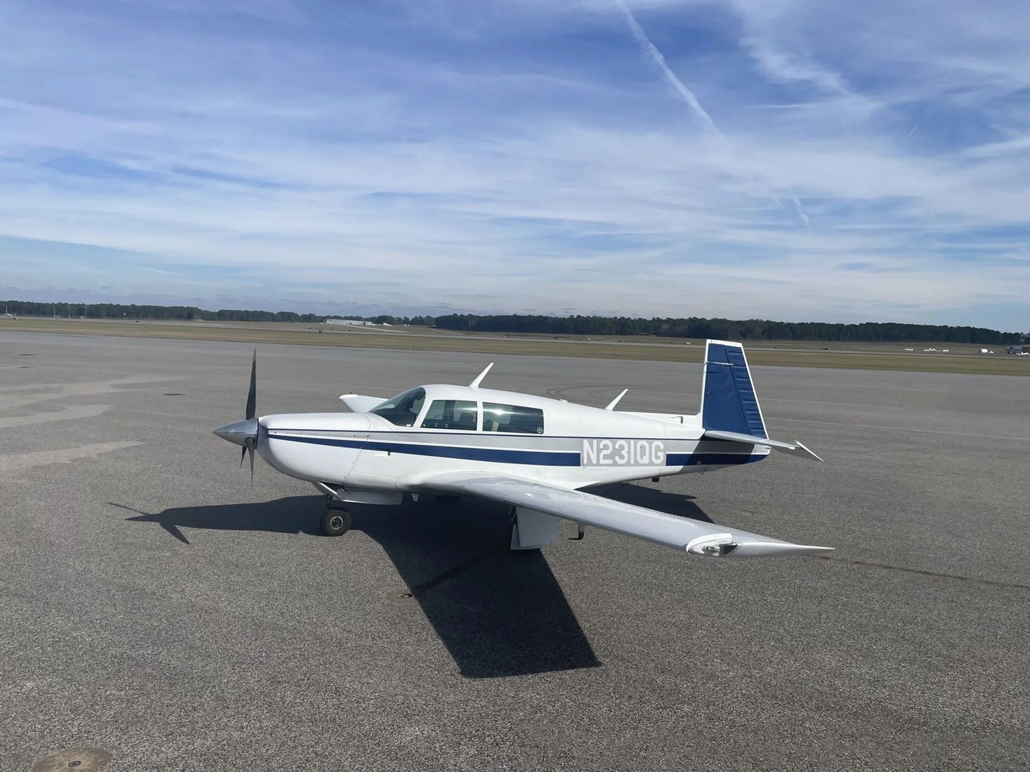 Side view of the aircraft with the runway in the background.
