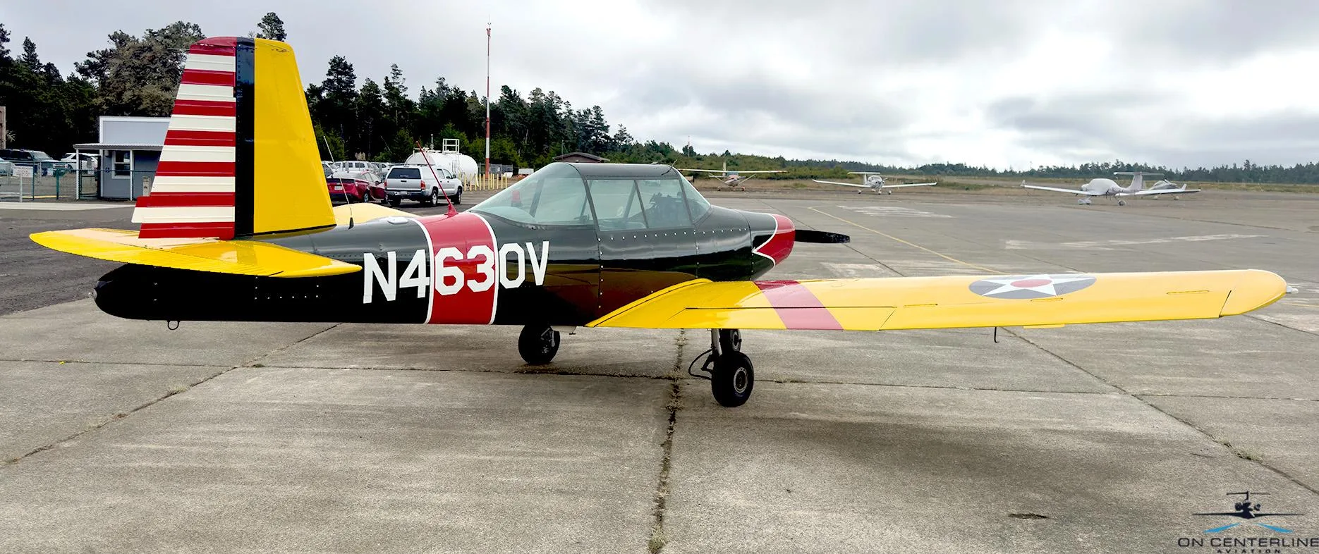A rear-side view of the N4630V aircraft, highlighting the US star insignia on the yellow wing and striped tail.