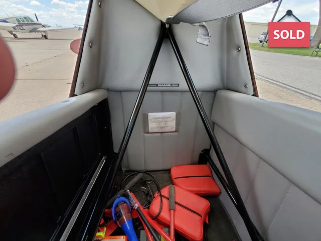 View of the aircraft's baggage area with red emergency supplies.