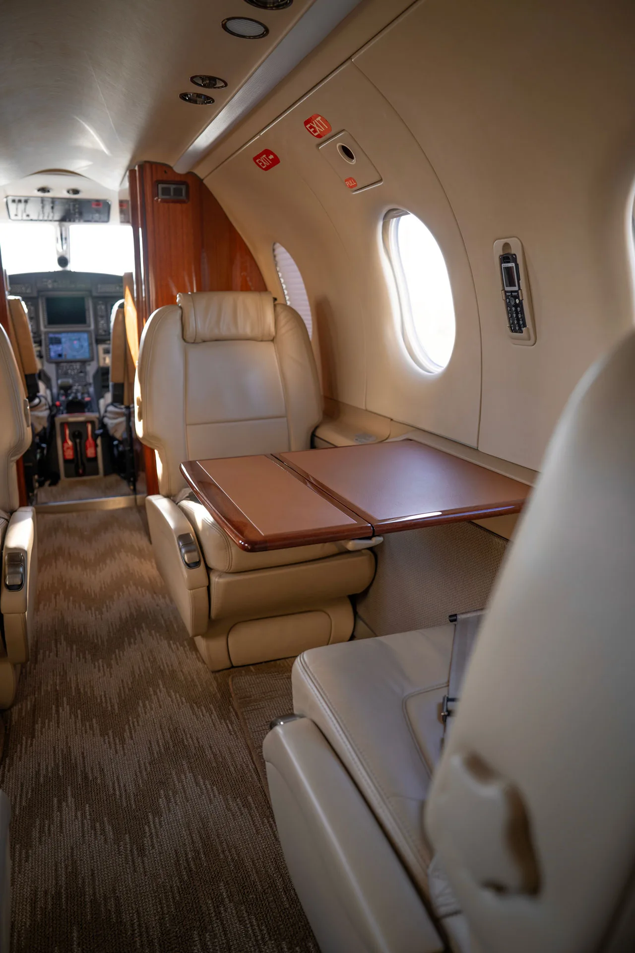 Interior view of the Pilatus PC-12 cabin with leather seats and a folding table.