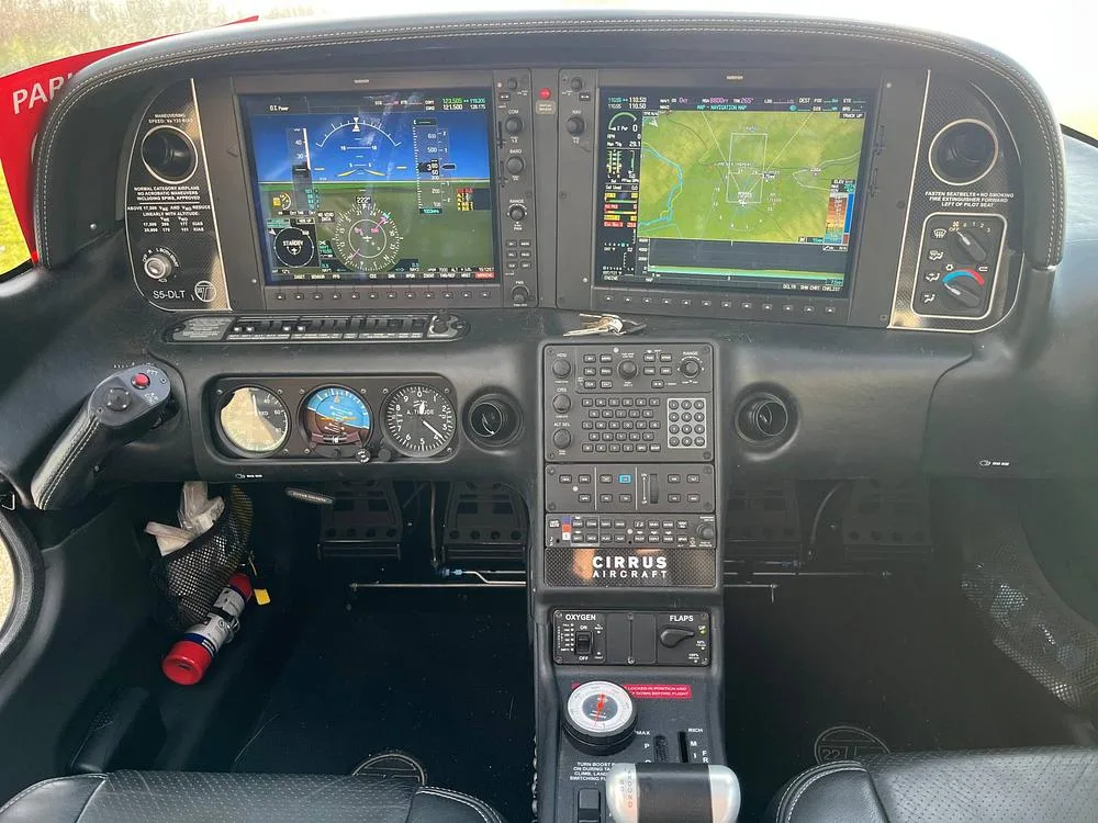 A detailed view of the Cirrus SR22T cockpit instrument panel, featuring two large glass displays and various controls.