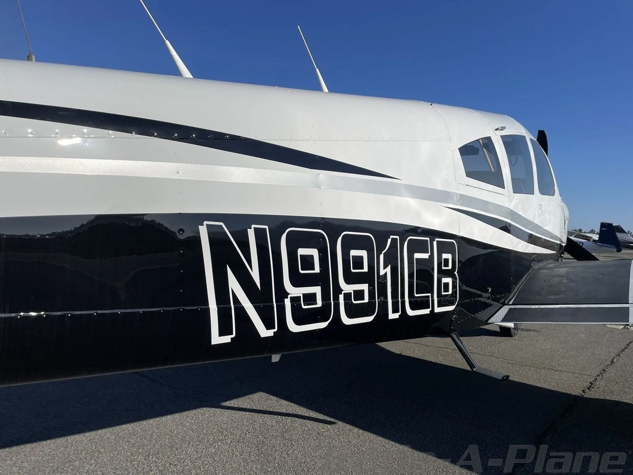 A close-up view of the black and white fuselage of the Piper Cherokee N991CB showing the registration number.