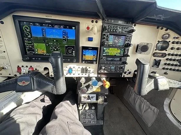 The cockpit of a small aircraft, showing the instrument panel with multiple digital displays and controls.
