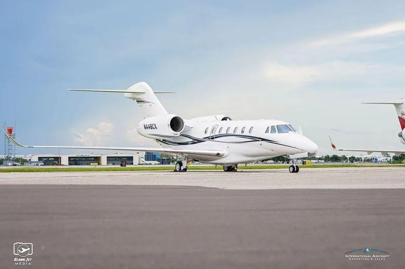 A side profile view of the white Cessna Citation XLS+ business jet N448CX parked on an airport tarmac.
