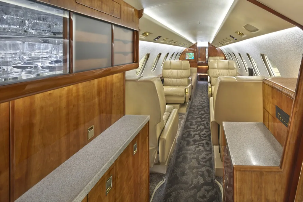 Hawker 850XP cabin interior with leather seats and wood accents.