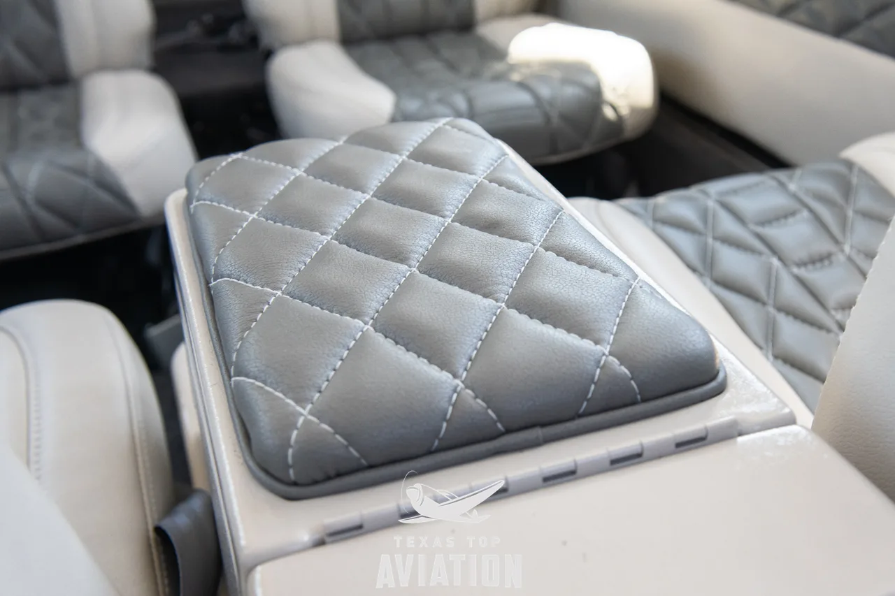 A close-up of a quilted grey armrest or console top in the aircraft's interior.