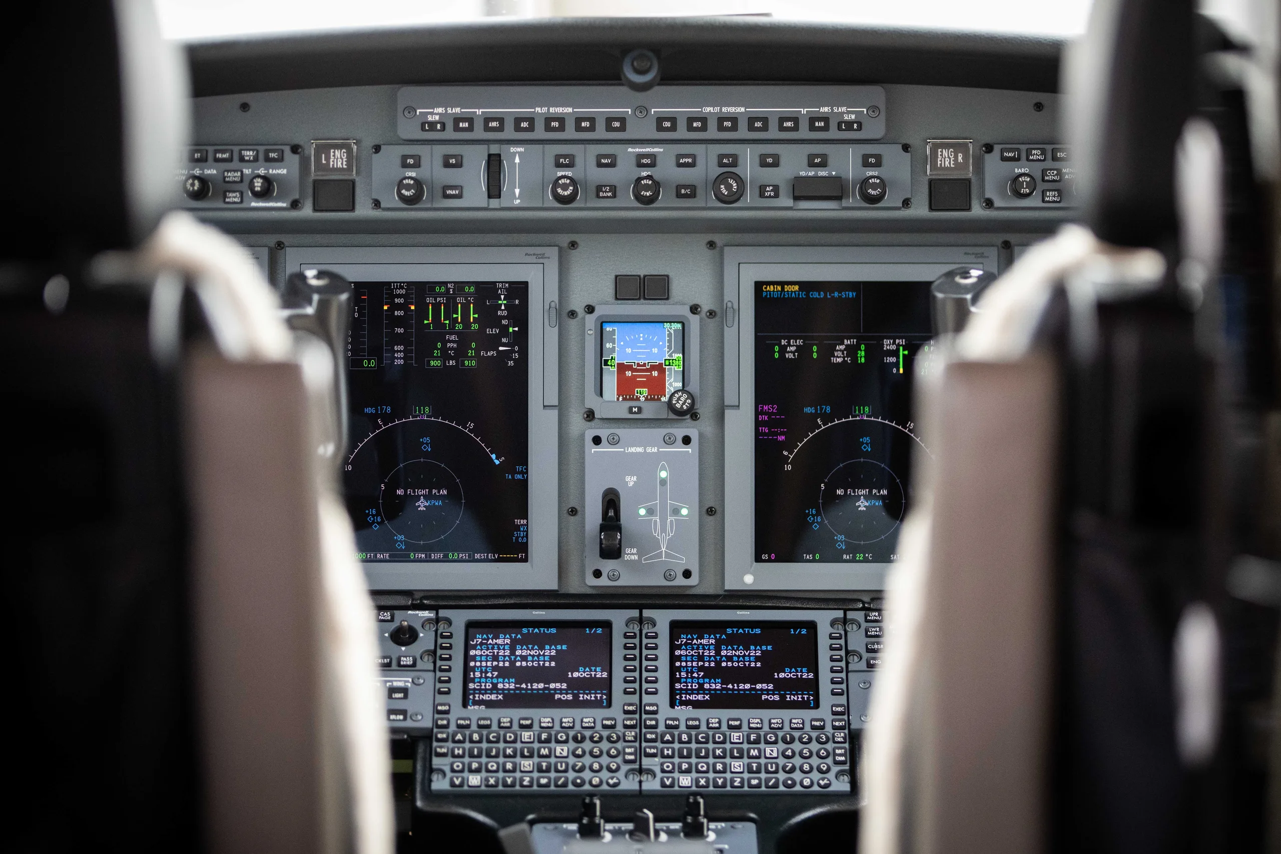 A wide view of a modern aircraft cockpit with multiple digital displays and control panels.