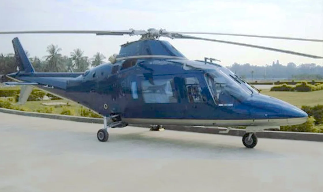 A dark blue AgustaWestland AW109 Power helicopter is shown on a helipad.
