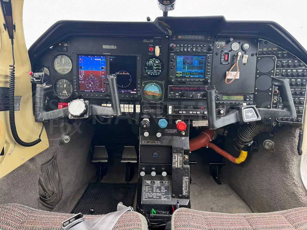 The cockpit of the N880RA aircraft, featuring a detailed instrument panel with multiple screens and controls.