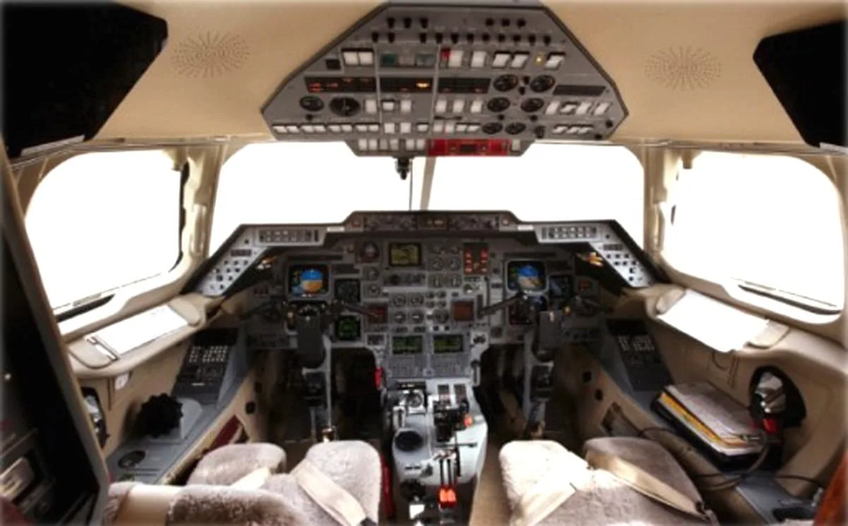 The detailed cockpit of a private jet with multiple screens and control panels.