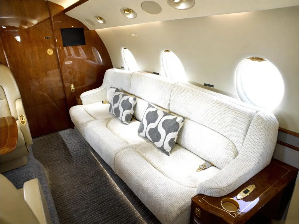 Interior view of the aircraft cabin with a couch and pillows.
