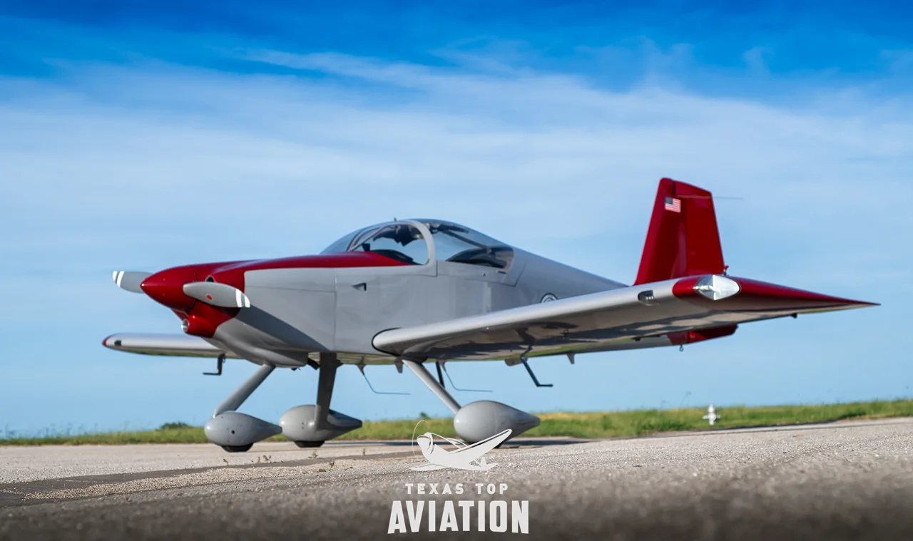 A low-angle side view of the gray and red single-engine aircraft, N1359L, on a paved surface.