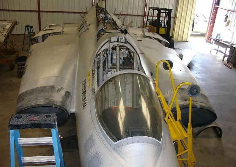 A front view of a partially disassembled Saab Draken aircraft with 'EXPERIMENTAL' written on its fuselage, inside a hangar.