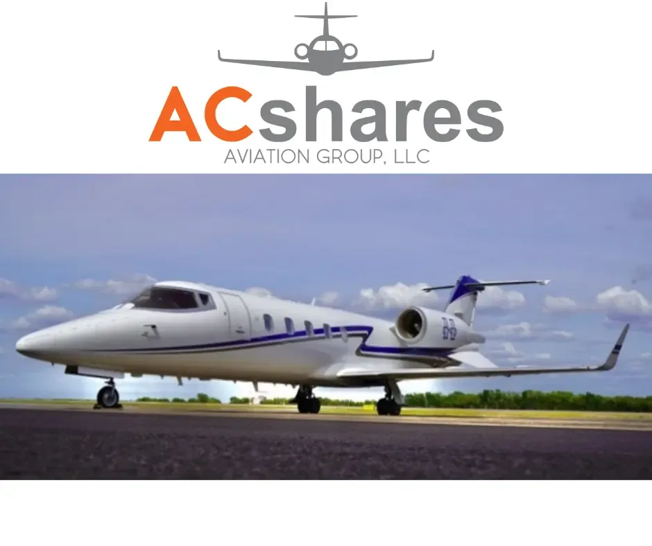 A white business jet with blue stripes sits on a tarmac under a partly cloudy sky.