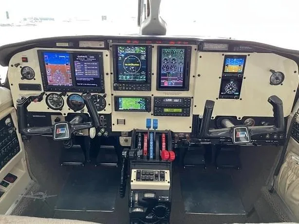 The aircraft cockpit features a modern glass panel with multiple digital displays and traditional control yokes.