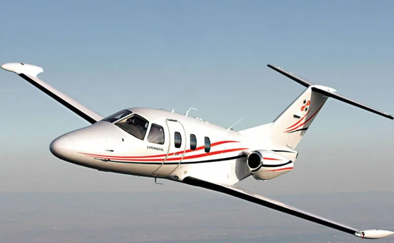 A white and red Cirrus Vision Jet in flight.