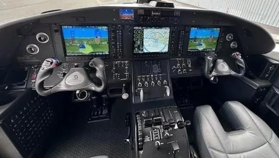 The modern cockpit features multiple large digital displays and a central control panel.