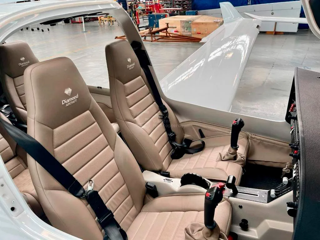 The tan leather interior seats of a Diamond DA40 aircraft, with "Diamond Aircraft" logos on the headrests.