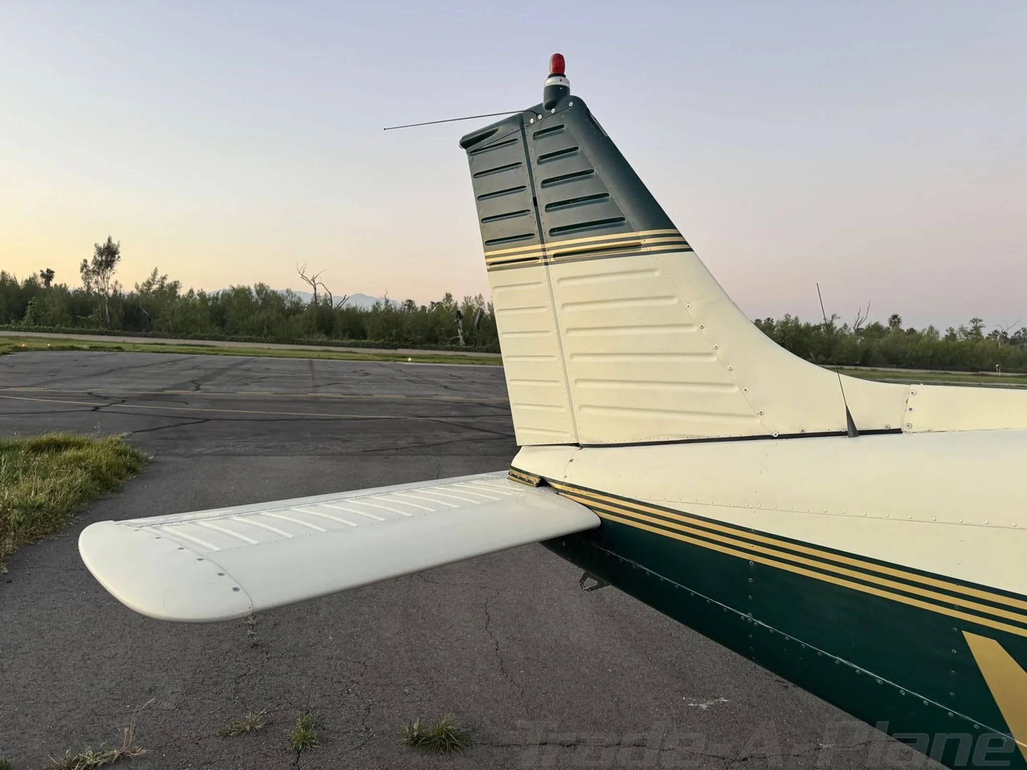A close-up view of the tail section of the N3683R aircraft, showing its green and white vertical and horizontal stabilizers.