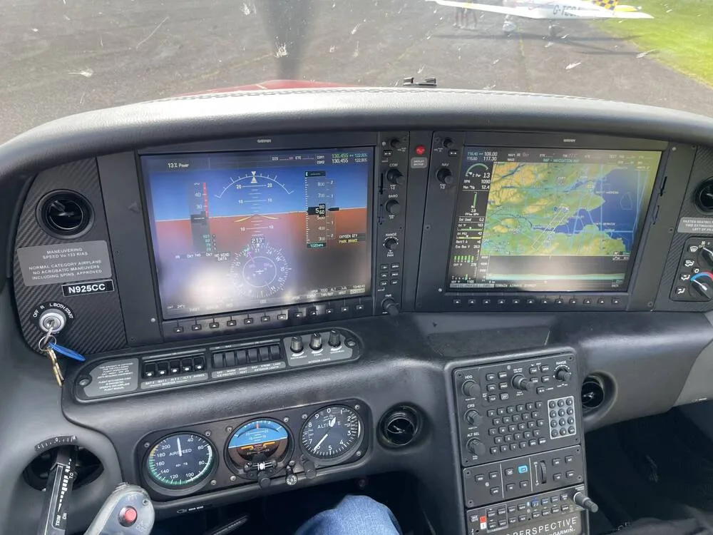 A close-up view of the Cirrus SR22 cockpit showing the Garmin G1000 NXi avionics suite with flight and navigation displays.