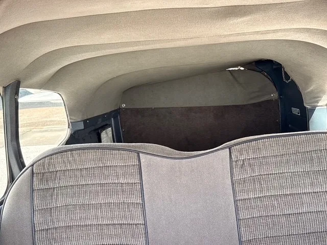 The rear gray fabric seat and headliner of a Cessna 182 Skylane interior.