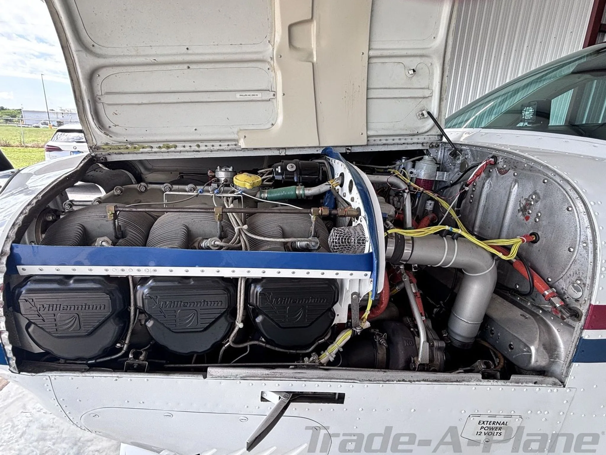 The engine compartment of the aircraft is open, revealing the engine components.