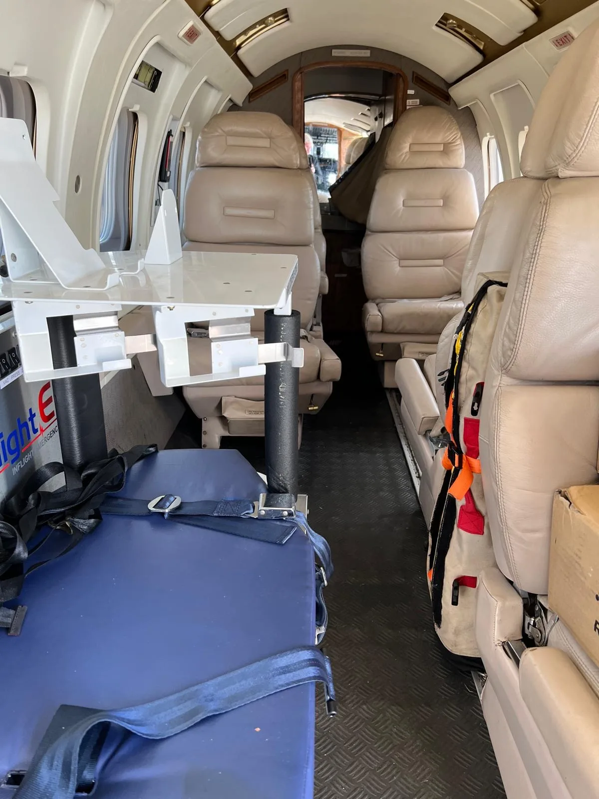 View of the aircraft's interior with seats and medical equipment.