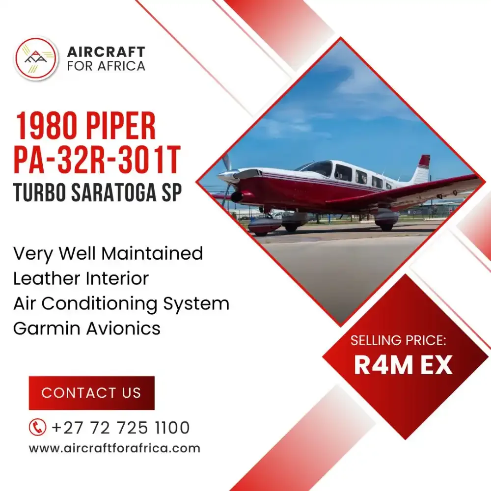 A red and white 1980 Piper PA-32R-301T Turbo Saratoga SP parked on an airfield under a blue sky.