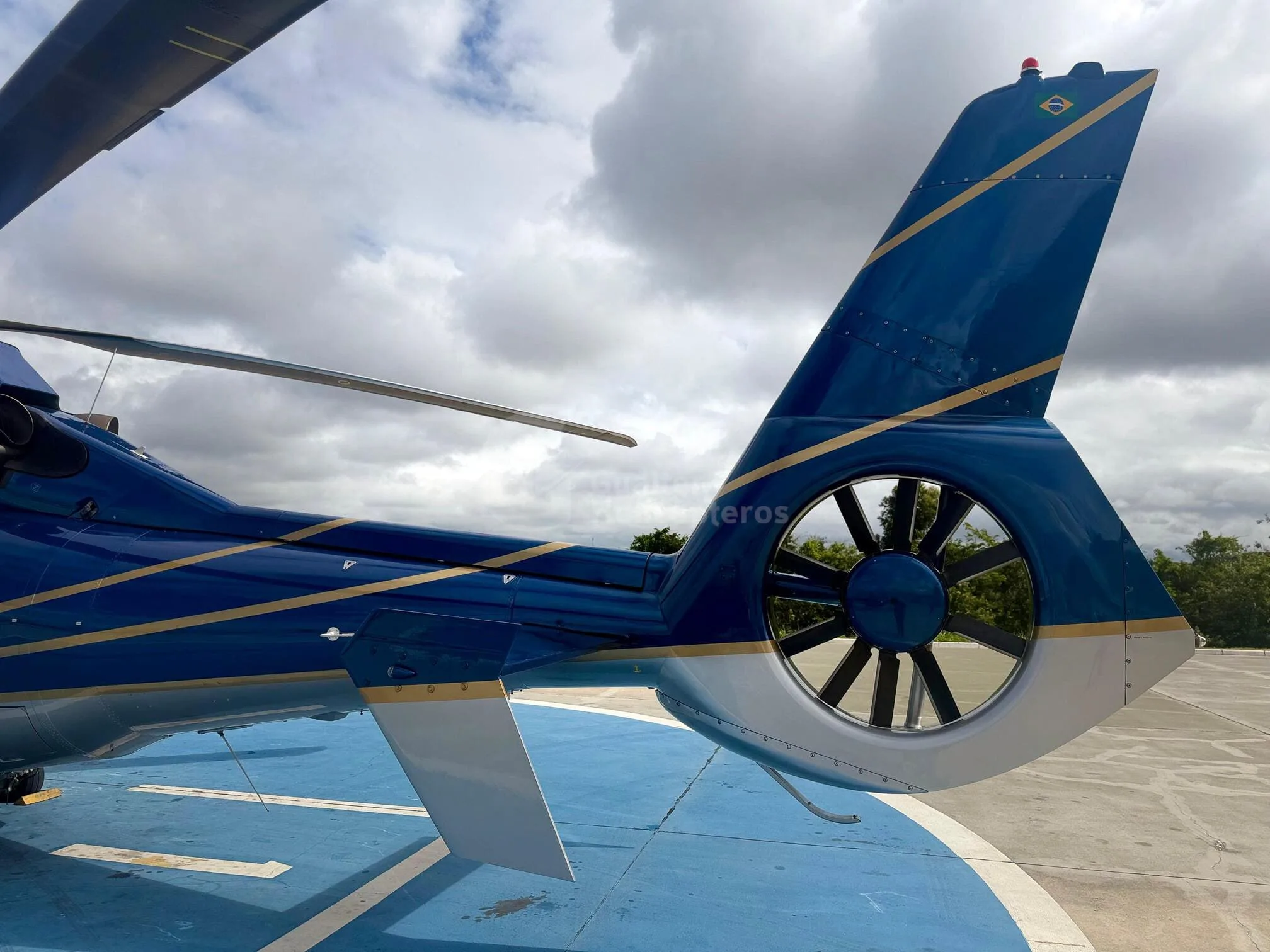 Close-up of the blue and light blue helicopter's tail with a fenestron and Brazilian flag detail.