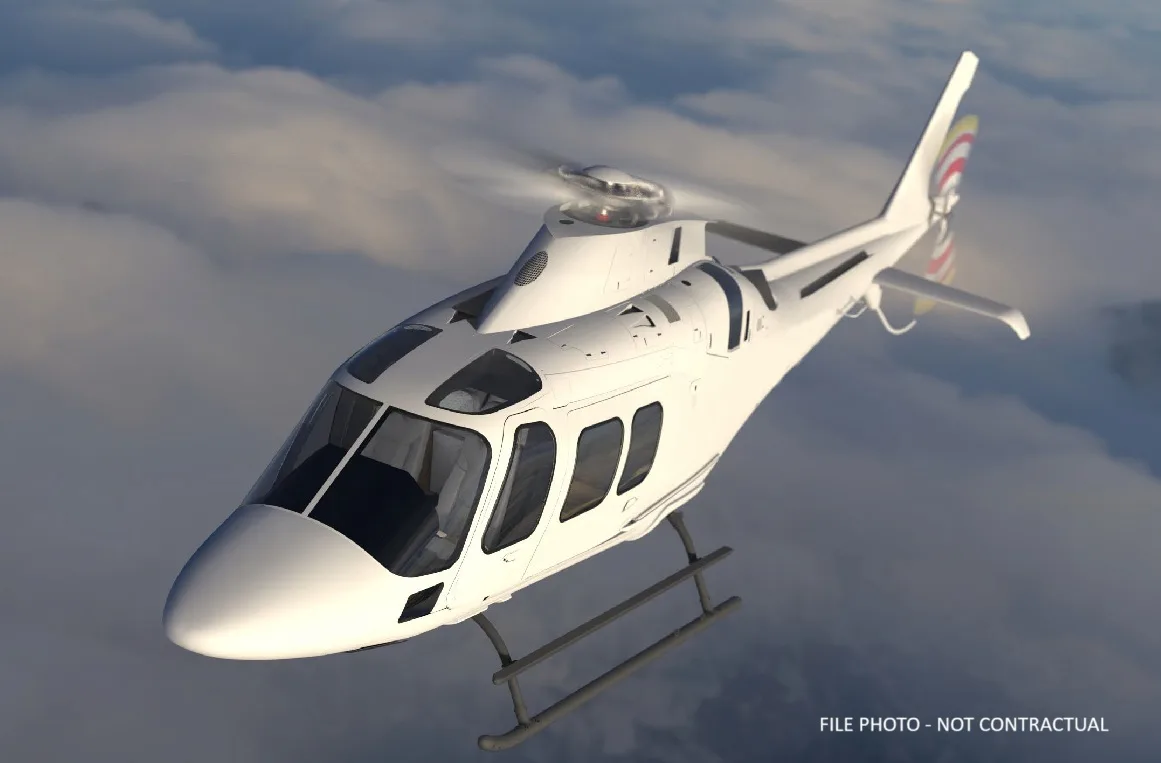 A white helicopter flying above the clouds.