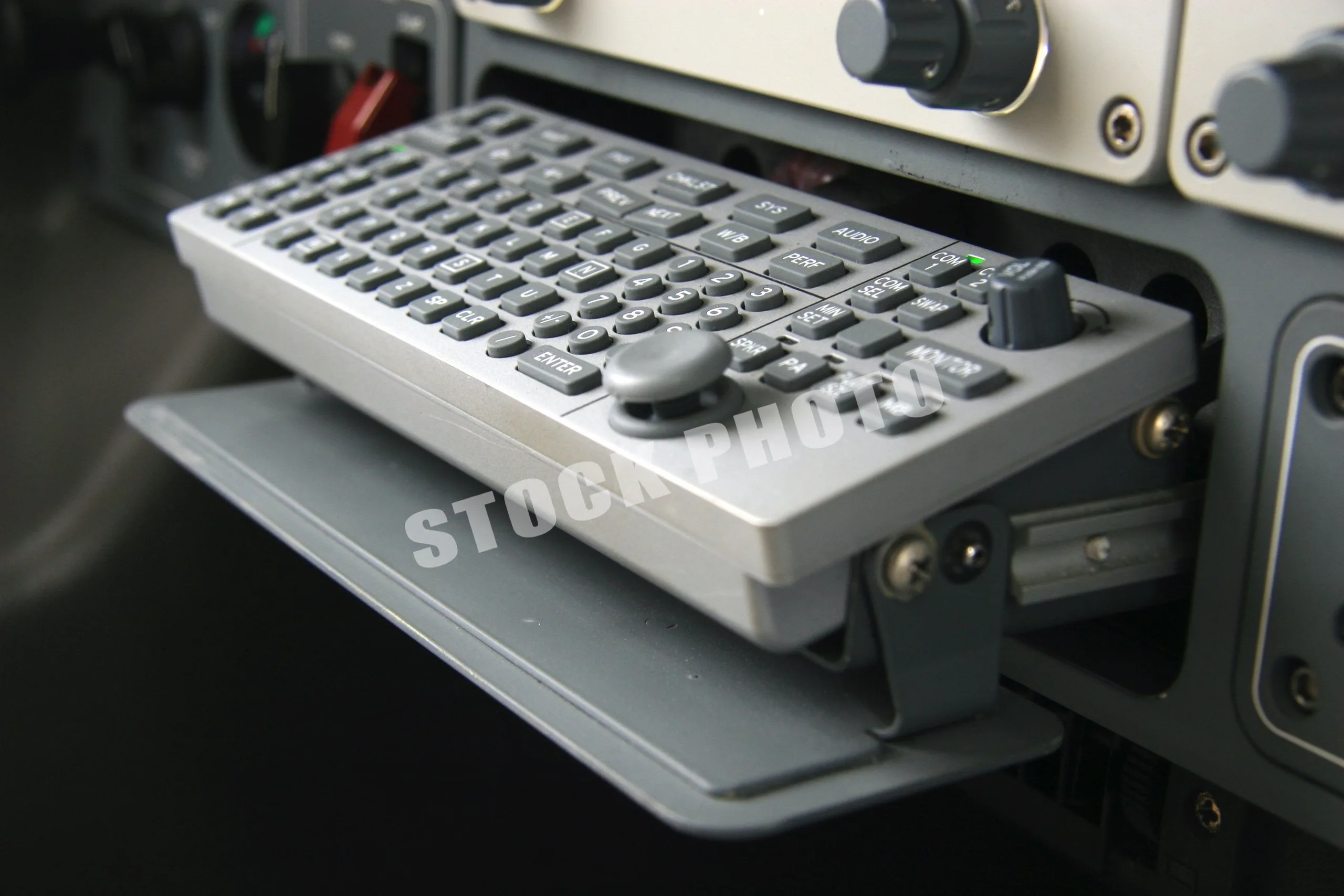 A close-up of a retractable keyboard and joystick controller in the Eclipse 500 cockpit.