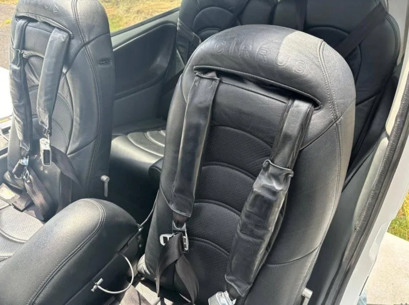 Close-up of the black leather rear seats with 'CIRRUS' embossed on the headrests and seatbelts.