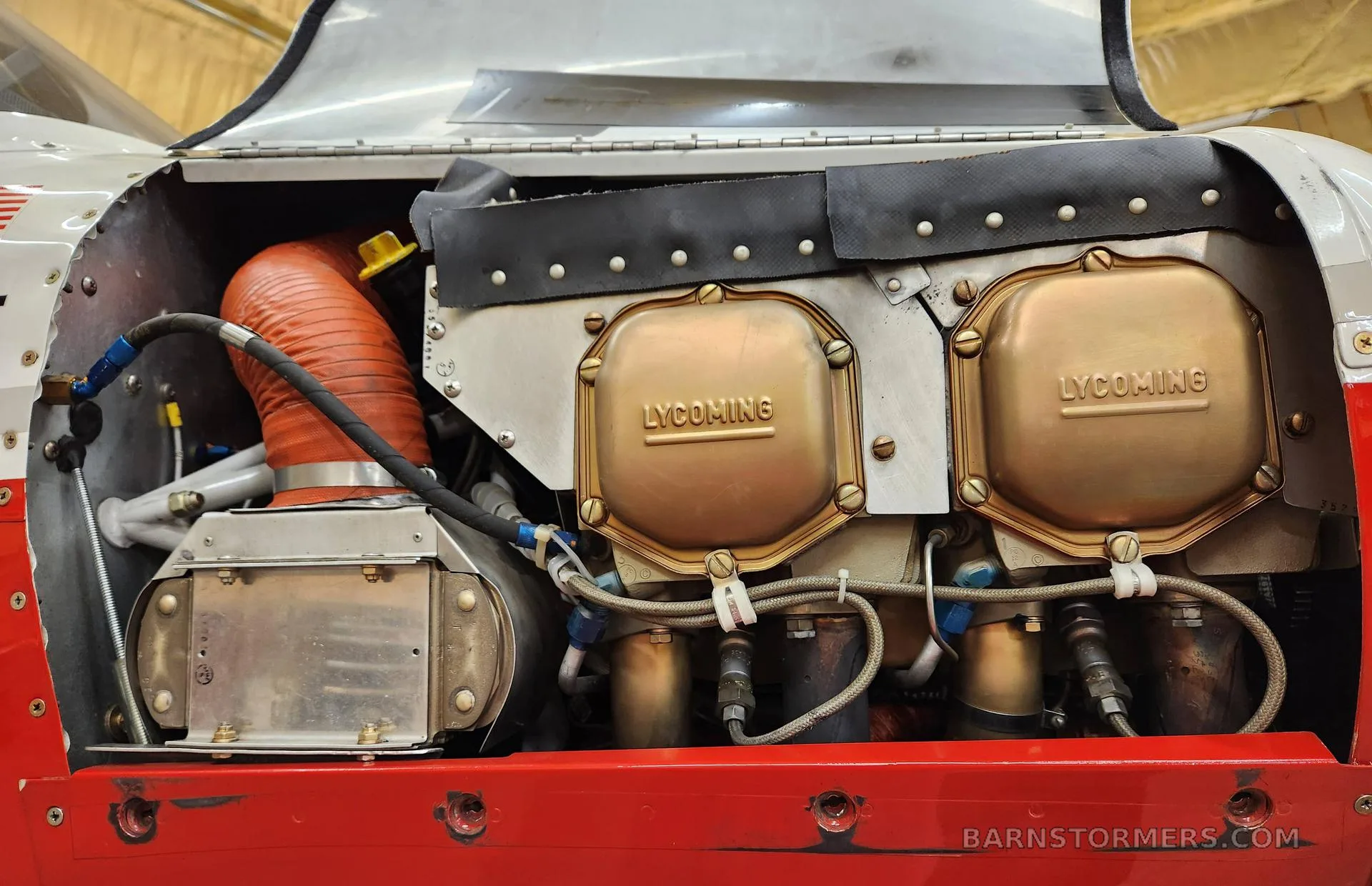 A close-up view of the Lycoming aircraft engine with its golden cylinder heads and associated plumbing.