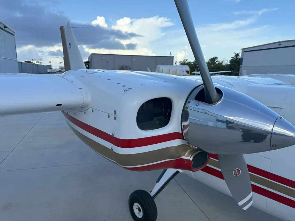 A close-up view of the right engine and propeller of the white and red twin-engine aircraft, N564BC.