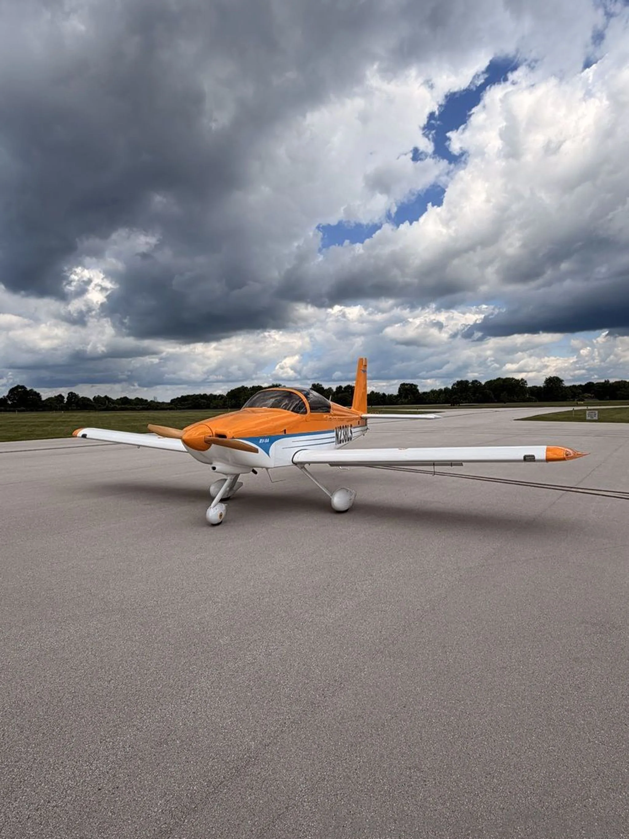 The aircraft is parked on a runway with a cloudy sky.