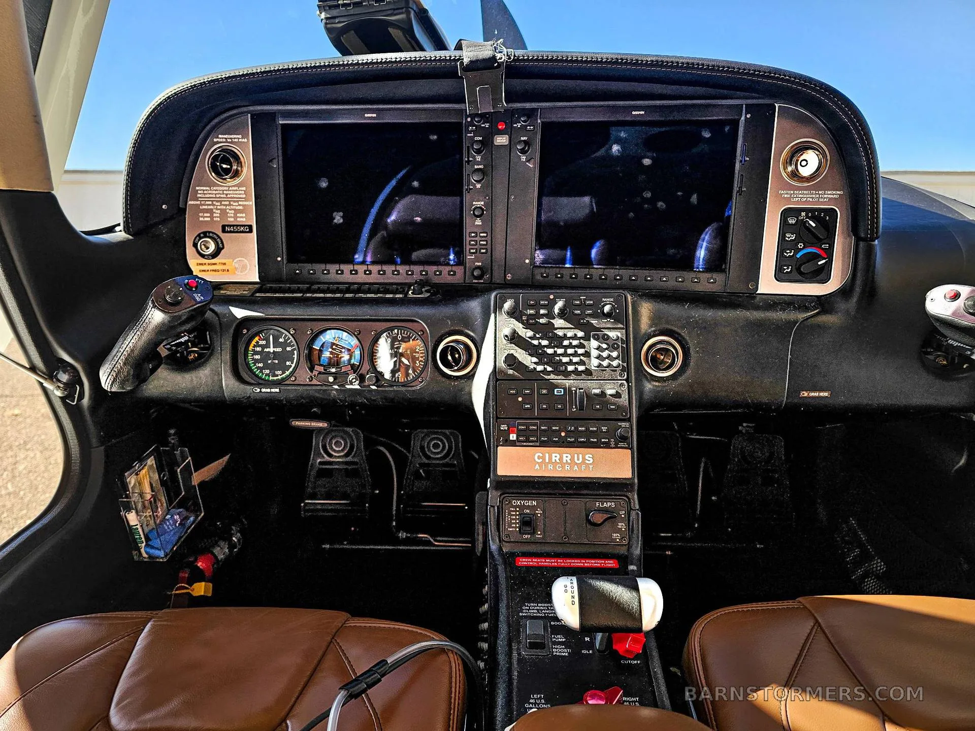The full instrument panel of a Cirrus aircraft cockpit, featuring two large glass displays and a central control stack.