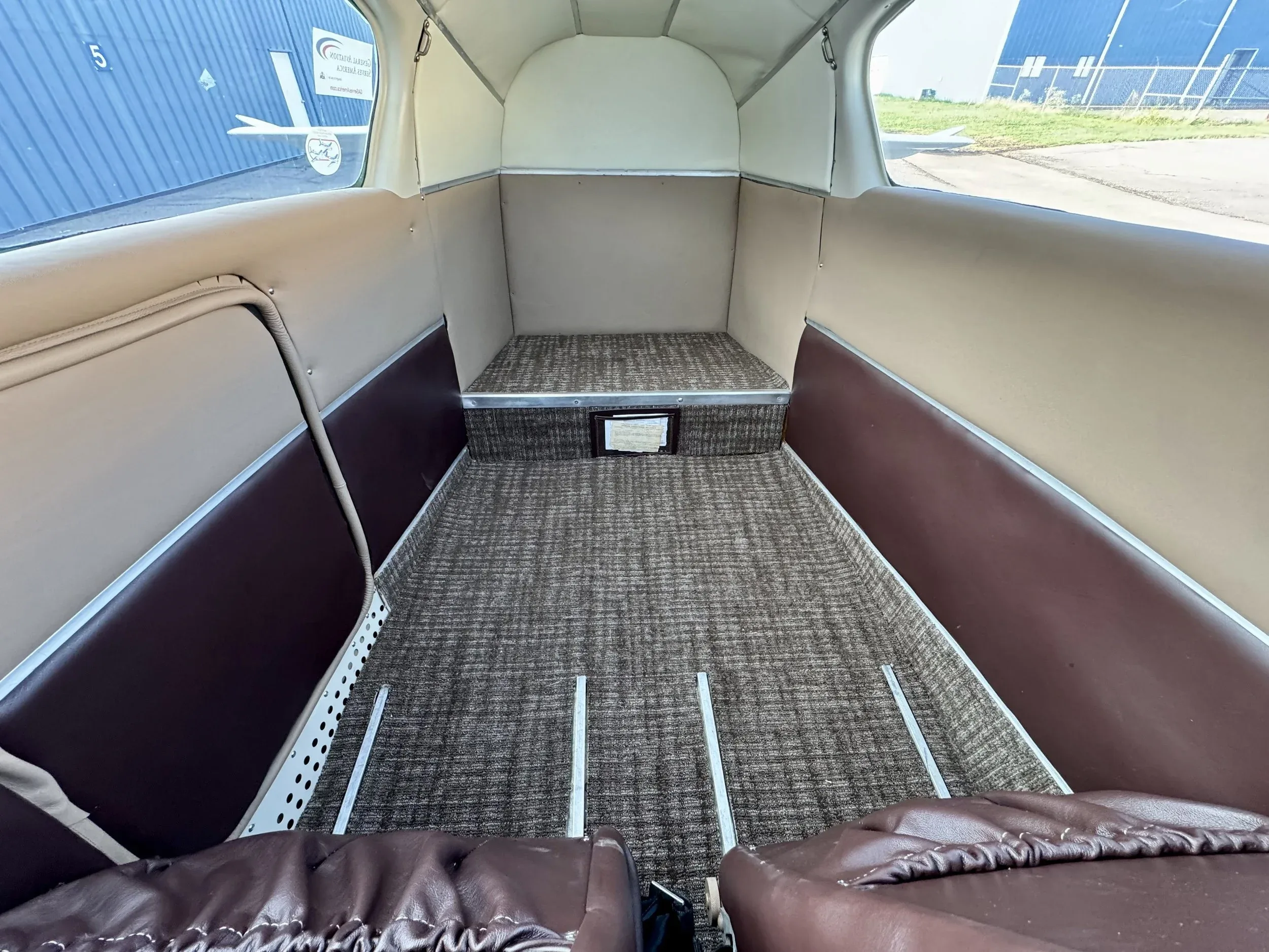 View of the rear cabin area of the Beechcraft Baron B55, showing the carpet and interior paneling.