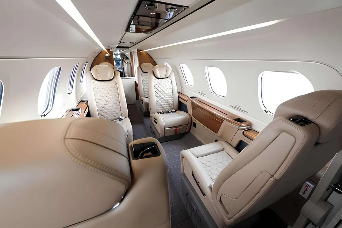 A view of the aircraft cabin with leather seats and wood trim.