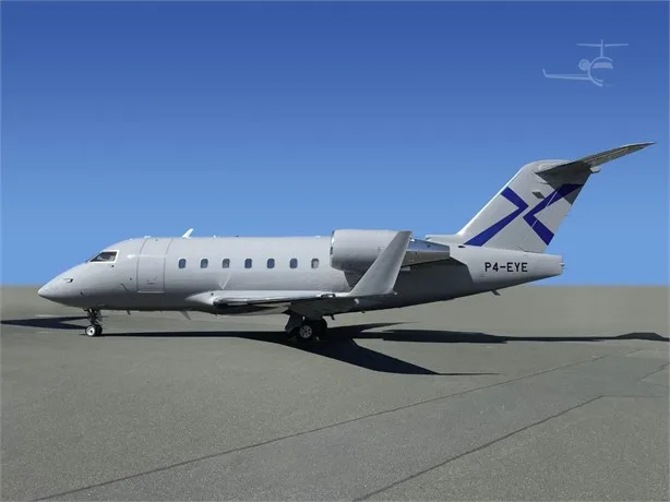 A light grey Bombardier Challenger 604 business jet with a blue tail logo, parked on an airfield under a clear blue sky.