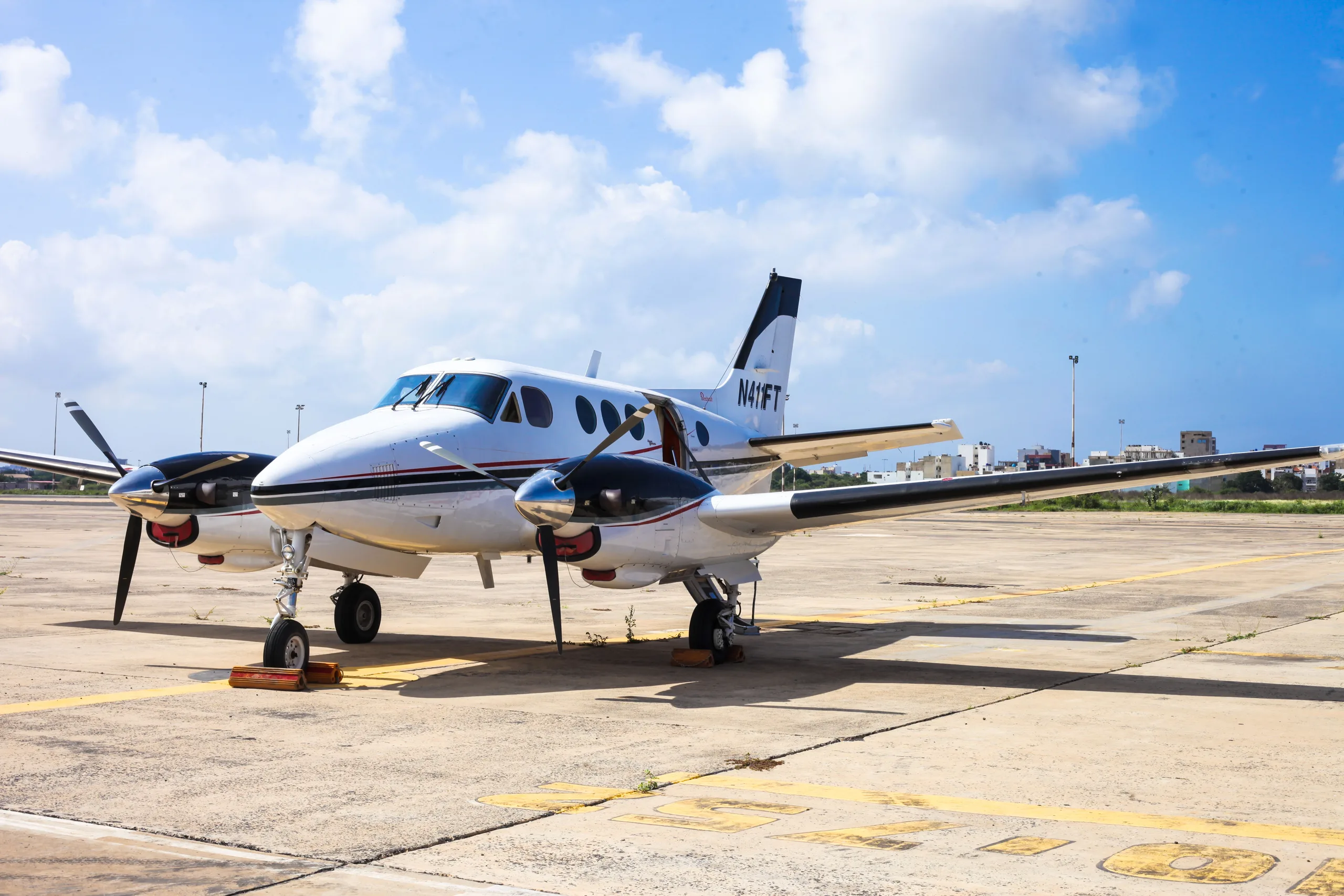 A King Air N411FT is parked on the tarmac with chocks in place.