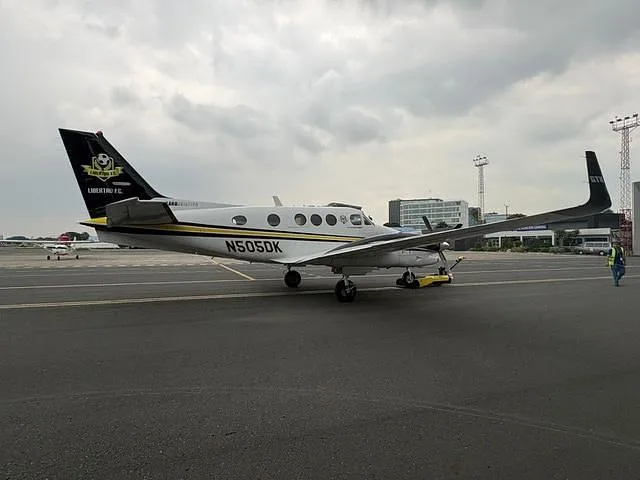 A white and black twin-engine turboprop aircraft with registration N505DK parked on an airfield.